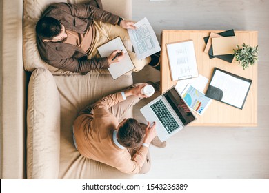 Overview Of Two Creative Interface Designers Sitting On Couch While Developing Brand New Software For Smartphones