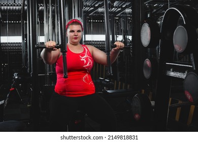 Overweigh Woman Working Out On A Fitness Equipment In Sport Club