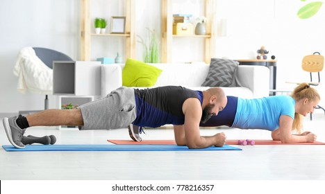 Overweight Couple Doing Exercises At Home