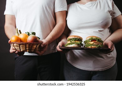 Overweight Couple With Healthy And Unhealthy Food