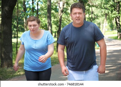 Overweight Couple Running In Green Park