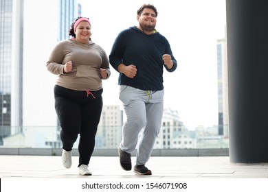 Overweight Couple Running Together Outdoors. Fitness Lifestyle