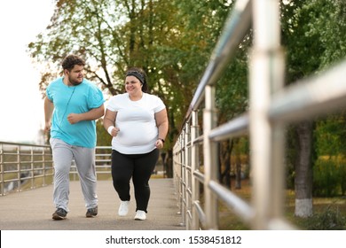 Overweight Couple Running Together In Park