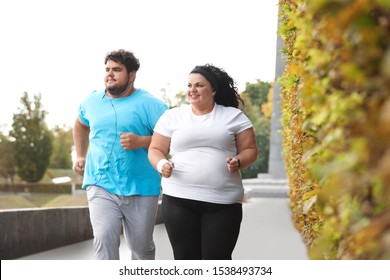 Overweight Couple Running Together In Park