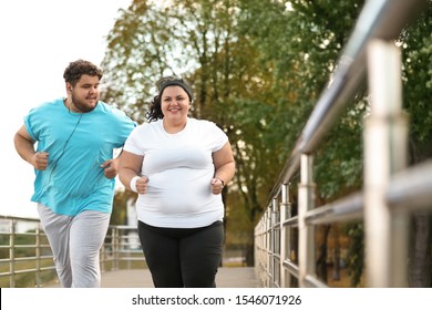 Overweight Couple Running Together In Park