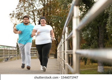 Overweight Couple Running Together In Park