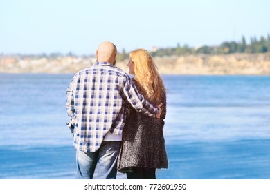 Overweight Couple Walking Near River On Sunny Day