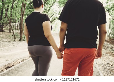 Overweight Couple Walking Together In Park. Weight Losing, Outdoor Activities, Healthy Lifestyle Concept.