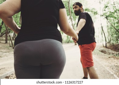 Overweight Couple Working Out Together. Husband Supporting His Wife In Weight Losing. Outdoor Activities, Fitness, Sport, Healthy Lifestyle Concept