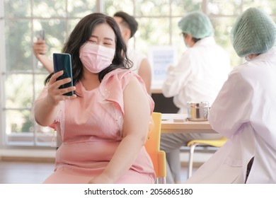 Overweight Fat Asian Woman Selfie By Phone At While Getting Covid Vaccine In Hospital, With Hand Nurse Injecting Vaccine. People With Smartphone For Social Online Of Self-presentation And Expression.