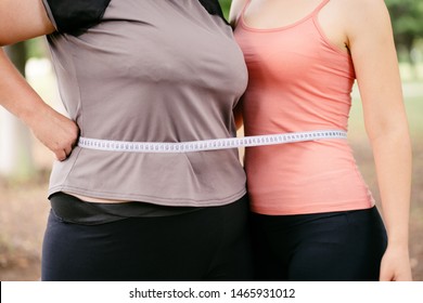 Overweight And Fit Women Standing Together Wrapped With Measure Tape. Dieting, Group Weight Loss And Health Care Concept