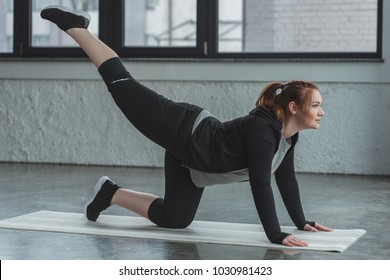 Overweight Girl Performing Exercise In Gym