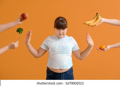Overweight girl rejecting healthy food on color background
