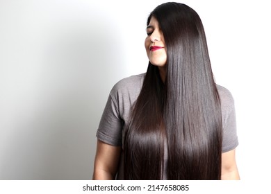 Overweight Latin young adult woman shows how silky and shiny her black hair is, very long, straight, very happy and proud of the beautiful hair with a beautiful haircut
