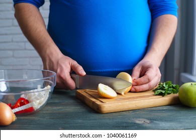 Overweight Man Cooking Diet Food. Plus-size Guy Chopping Onion Preparing Low-calorie Meals. Weight Losing, Dieting And Healthy Lifestyle