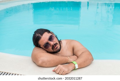 An Overweight Man Dozes Off At The Side Of The Swimming Pool. Exhausted Or Bored Vacationer.