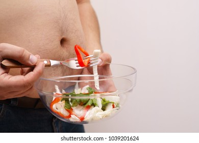 Overweight Man Eating Salad. Guy With Obese Belly Tasting Vegetables. Copy Space. Weight Losing, Dieting And Healthy Lifestyle