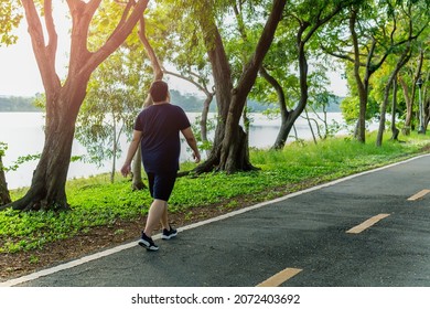 Overweight Man Exercising Walking To Burn Fat Out In The Park.