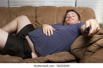 overweight man just watching tv on the couch