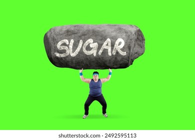 Overweight Man Lifting Large Rock With Sugar Written On It in the studio with green screen background - Powered by Shutterstock