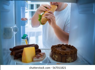 Overweight man on diet break diet with big sandwich roll