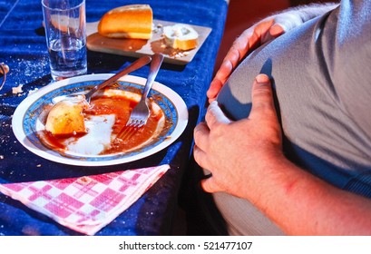 Overweight Man Resting After Eating Too Much Food.