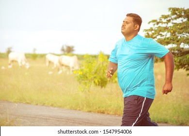 Overweight Man Running On Road - Concept Of Fat Man Fitness - Obese Person Jogging To Reduce The Weight.