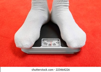 Overweight Man Standing On A Retro Style Weighing Machine 