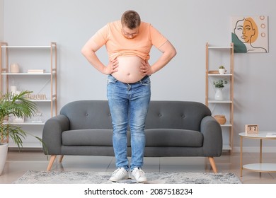 Overweight Man Standing On Scales At Home. Weight Loss Concept