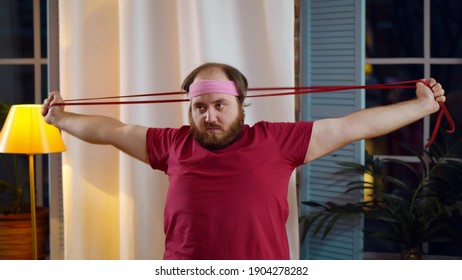 Overweight Man Stretching Home Using Sports Equipment. Portrait Of Fat Guy With Skipping Rope Exercising In Living Room Losing Weight. Stout Male Working Out At Home