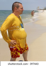 Overweight Man Striking A Pose To Impress Girls On The Beach