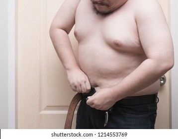 Overweight Man Trying To Fasten Too Small Jean Pants. Represent Of Fat, Obesity, Big Belly.