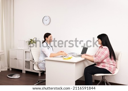 Overweight mature woman consulting with nutritionist in clinic