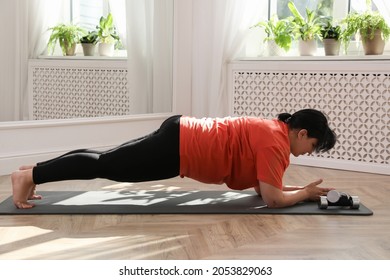 Overweight Mature Woman Doing Plank Exercise At Home