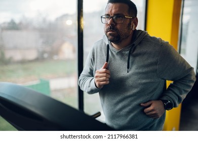 Overweight Middle Aged Man In Sportswear Running On Treadmill In The Gym. Fitness And Healthy Lifestyle.