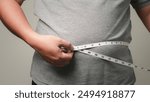 Overweight or obese man on white background. Fat mens body measurements. he is dieting and losing weight. Healthcare, medicine concept.  he is dieting and losing weight. 