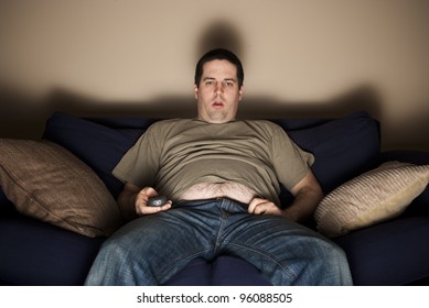 Overweight slob watches TV with belly showing