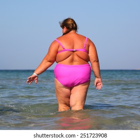 Overweight Woman Bath In Sea - View From Back