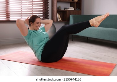 Overweight Woman Doing Abs Exercise On Yoga Mat At Home