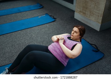 Overweight Woman Doing Exercise On Mat In Gym