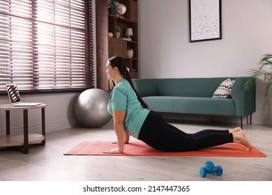 Overweight Woman Doing Exercise On Yoga Mat At Home