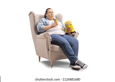 Overweight woman with a drink and a bag of chips sitting in an armchair isolated on white background