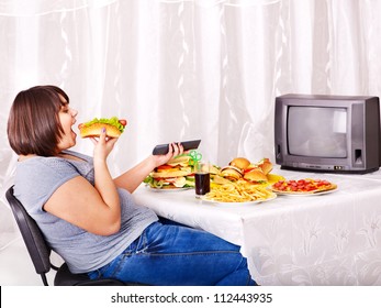 Overweight Woman Eating Fast Food And Watching TV.