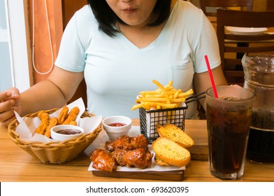 Overweight woman eating junk food.