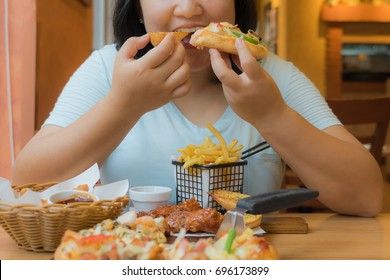 Overweight woman is eating large meal,fat asian girl enjoy eating fast food