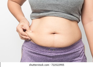 Overweight woman hand pinching excessive belly fat on gray background, Healthy concept 