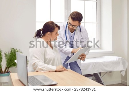Overweight woman having consultation at doctor's office. Portrait of confident doctor holding report file with appointment and giving consultation to a fat patient examination room in clinic.