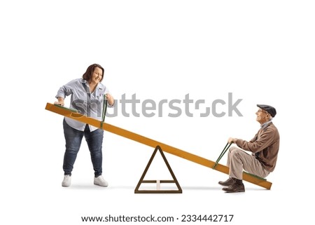 Overweight woman lifting an elderly man on a seesaw isolated on white background