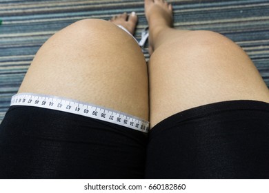 overweight woman measure her leg