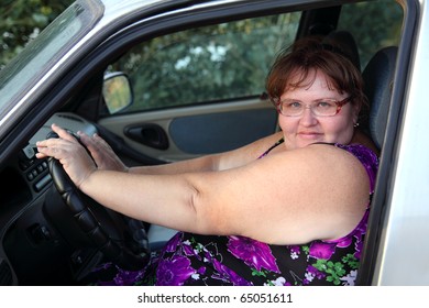 Overweight Woman Sitting Behind The Wheel Of Car